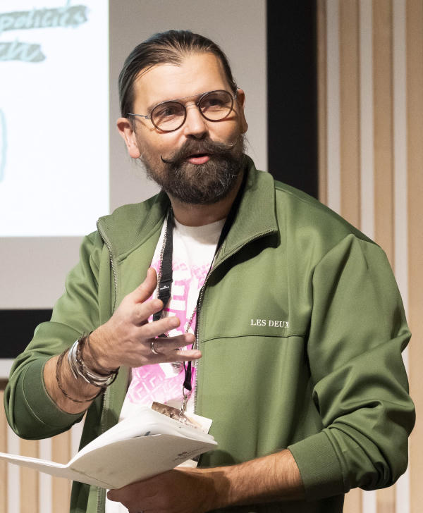 Man presenting with papers in his hands. Photo: Thor Brødreskift
